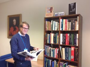 Second hand bookshelves in the museum with volunteer David Whitehead looking at a book