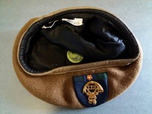 A Light Infantry beret lies upside down, showing the hand sewn accession label inside