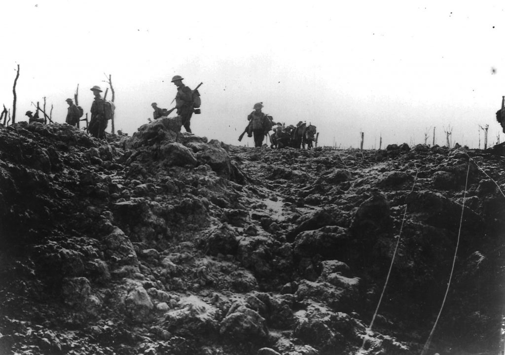 Soldiers march through a shelled battlefield.