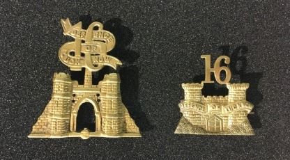 Two badges decorated with the number 16, a ribbon that reads 'Defence of Lucknow' and a gate structure.