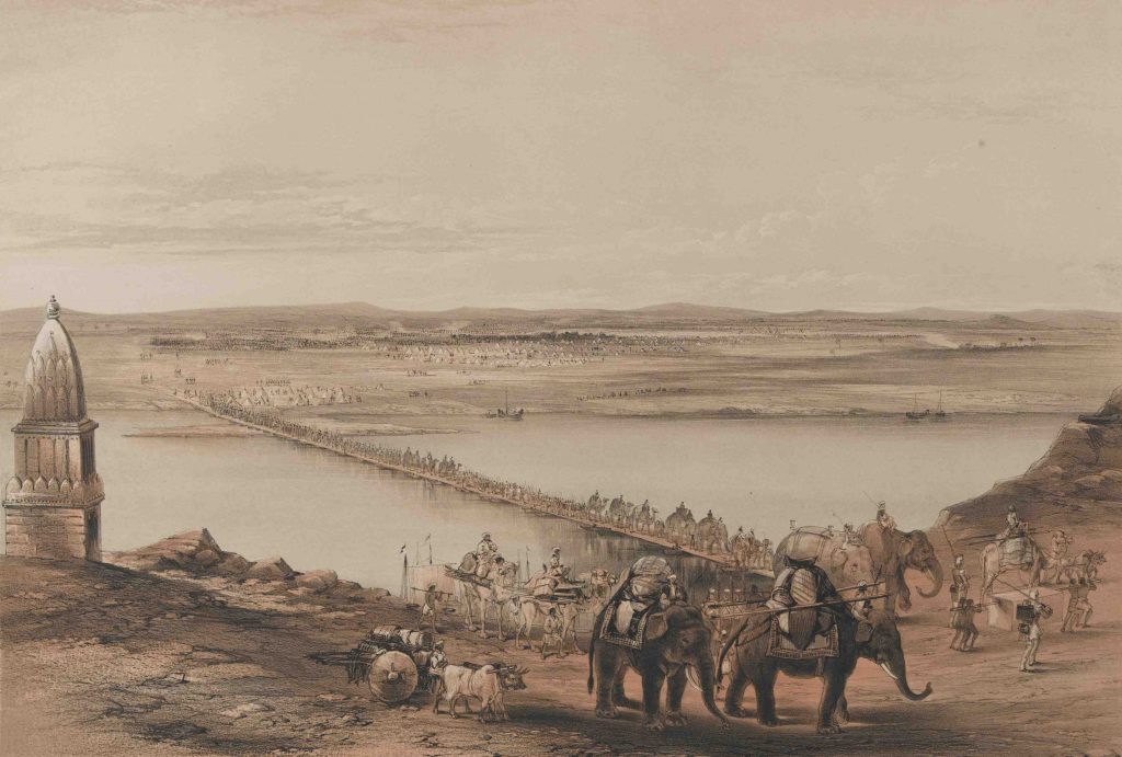 Series of caravans, carts and elephants walking across a bridge over a river